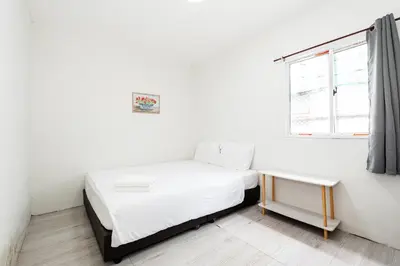 a white bedroom with a bed and a window at XX GO INN Siriraj Wang Lang - โก อินน์ โรงพยาบาลศิริราช วังหลัง in Bangkok
