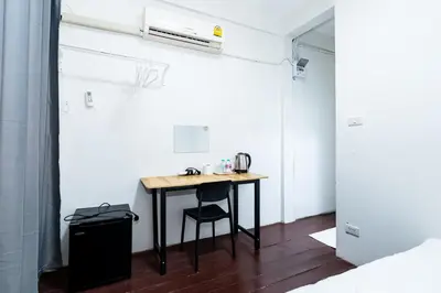 a small table with a chair in a room at XX GO INN Siriraj Wang Lang - โก อินน์ โรงพยาบาลศิริราช วังหลัง in Bangkok