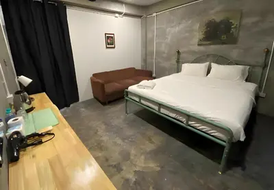 a bedroom with a bed and a couch in it at xx GO INN BTS Ari - โกอินอารีย์ in Bangkok