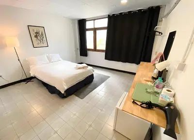 a bedroom with a bed and a desk and a window at xx GO INN BTS Ari - โกอินอารีย์ in Bangkok