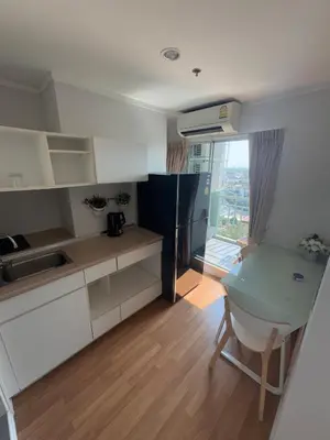 a kitchen with white cabinets and a desk and a window at Minimalist Condo in Pinklao in Bangkok