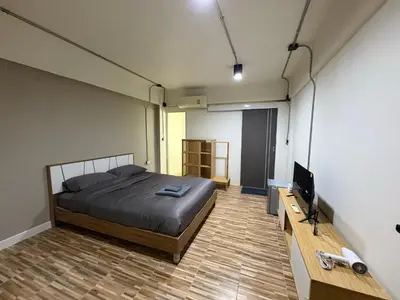 a bedroom with a bed and a flat screen tv at The beeroom by BoonmeeApt in Sathani Sam Sen
