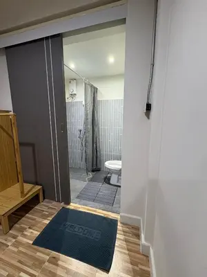 a bathroom with a shower and a toilet and a mirror at The beeroom by BoonmeeApt in Sathani Sam Sen