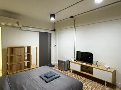 a bedroom with a bed and a flat screen tv at The beeroom by BoonmeeApt in Sathani Sam Sen