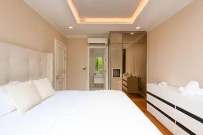 a bedroom with a white bed and a ceiling at Modern Luxury Poolhaus with Lift in Khlong Toei