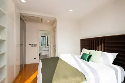 a bedroom with a large white bed with green pillows at Modern Luxury Poolhaus with Lift in Khlong Toei