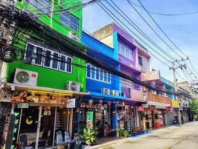 a group of buildings on a street with shops at Tropical Apartments 1 No Stairs easy peasy in Bangkok
