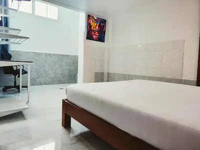 a bedroom with a bed and a desk and a stained glass window at Tropical Apartments 1 No Stairs easy peasy in Bangkok