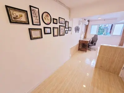a room with a white wall with pictures on it at Crane nest 2 mezzanine opaque view in Bangkok