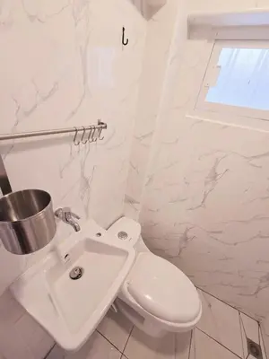 a white bathroom with a toilet and a sink at Crane nest 2 mezzanine opaque view in Bangkok