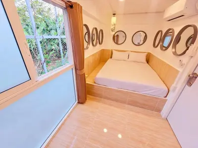 a small room with a bed and a window at Crane nest 4 lower floor in Bangkok