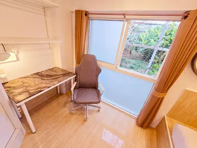 a room with a desk and a chair and a window at Crane nest 4 lower floor in Bangkok
