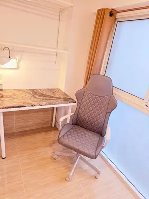 a desk and a chair in a room with a window at Crane nest 4 lower floor in Bangkok