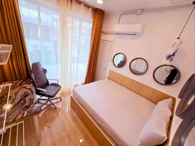 a small bedroom with a bed and a chair at Crane nest 5 townhouses view with french balcony in Bangkok