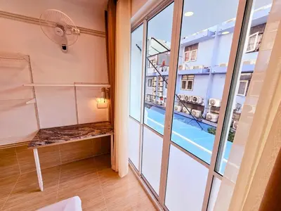 a room with a balcony with a bench and a window at Crane nest 5 townhouses view with french balcony in Bangkok