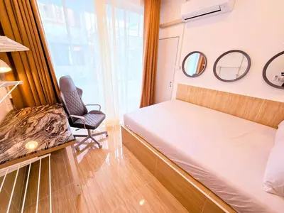 a bedroom with a bed and a chair and mirrors at Crane nest 5 townhouses view with french balcony in Bangkok
