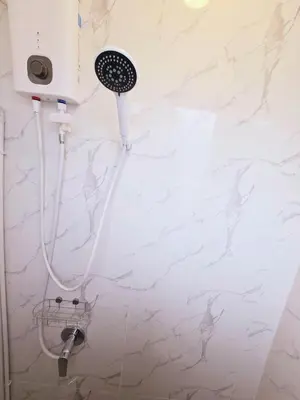 a shower in a bathroom with a white wall at Crane nest 6 Townhouse View in Bangkok
