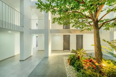 a hallway with a tree in the middle of a building at SHIN Patara Living Hotel in Bangkok