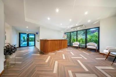 an office lobby with a reception desk and chairs at SHIN Patara Living Hotel in Bangkok