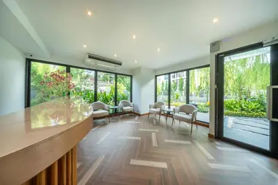 a lobby with a bar with chairs and windows at SHIN Patara Living Hotel in Bangkok