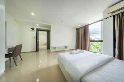 a bedroom with a bed and a desk and a window at SHIN Patara Living Hotel in Bangkok