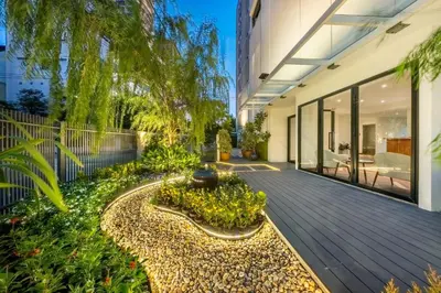 a wooden deck with a garden in a house at SHIN Patara Living Hotel in Bangkok