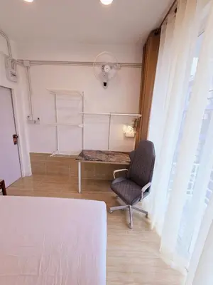 a room with a table and a chair and a fan at Crane nest 8 townhouses view middle with balcony in Bangkok