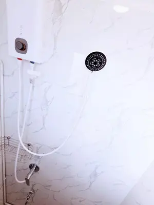 a shower with a hose attached to a wall at Crane nest 9 palm tree villa view in Bangkok
