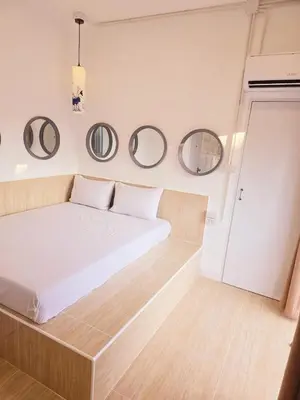 a bedroom with a bed with two mirrors on the wall at Crane nest 9 palm tree villa view in Bangkok