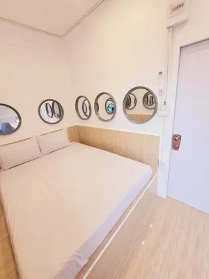 a bed in a room with four eyeballs on the wall at Crane nest 10 banana farm view in Bangkok