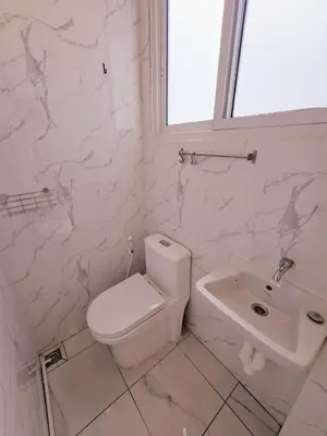 a white bathroom with a toilet and a sink at Crane nest 12 mansion view in Bangkok
