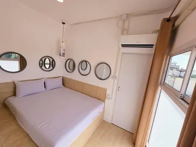 a small bedroom with a bed and mirrors on the wall at Crane nest 12 mansion view in Bangkok