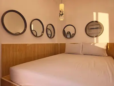 a bedroom with three mirrors on the wall and a bed at Crane nest 13 Bangkok downtown view in Bangkok