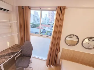 a room with a window with a chair and a mirror at Crane nest 13 Bangkok downtown view in Bangkok