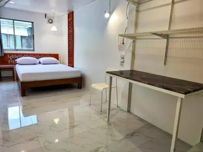 a room with a bed and a desk in a room at Tropical Apartments 8 Explore Bangkok MRT Lumpini in Bangkok