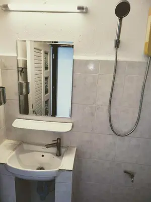 a bathroom with a sink and a shower with a mirror at Tropical Apartments 8 Explore Bangkok MRT Lumpini in Bangkok