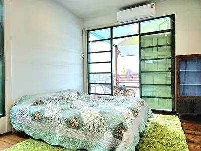 a bedroom with a bed and a large window at Sabai Sabai House Koh Kret in Ban Laem Yai