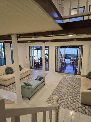a living room with couches and tables and glass doors at Sabai Sabai House Koh Kret in Ban Laem Yai