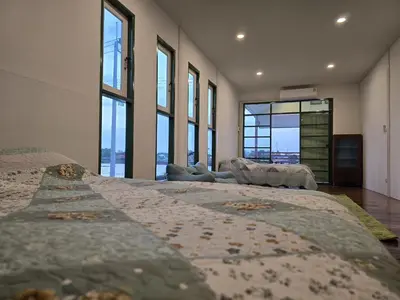 a large bedroom with two beds and large windows at Sabai Sabai House Koh Kret in Ban Laem Yai