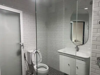 a bathroom with a toilet and a sink and a mirror at Luck Hotel Huai Khwang MRT Ratchada in Bangkok