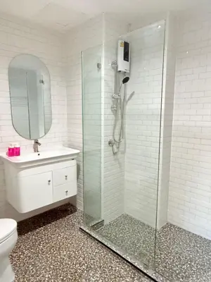 a bathroom with a shower and a toilet and a sink at Luck Hotel Huai Khwang MRT Ratchada in Bangkok