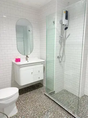 a bathroom with a toilet and a glass shower at Luck Hotel Huai Khwang MRT Ratchada in Bangkok