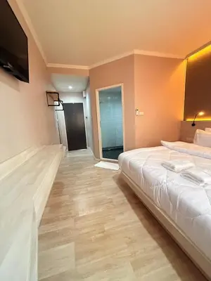 a hotel room with a bed and a flat screen tv at Luck Hotel Huai Khwang MRT Ratchada in Bangkok