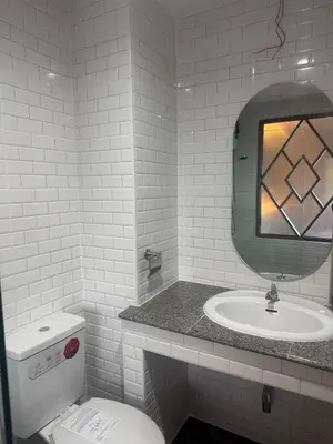 a white bathroom with a sink and a mirror at Luck Hotel Huai Khwang MRT Ratchada in Bangkok