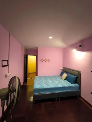 a bedroom with a bed in a room with pink walls at Santo house Bangkok in Bangkok