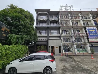 a white car parked in front of a building at Sukhum Rajamangala-Phatthanakan Rooms in Bangkok