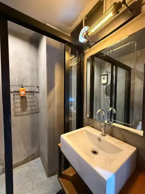 a bathroom with a white sink and a mirror at Sukhum Rajamangala-Phatthanakan Rooms in Bangkok