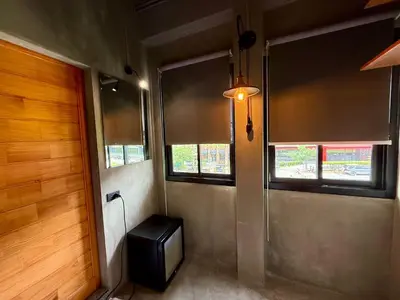 a room with a small television and a window at Sukhum Rajamangala-Phatthanakan Rooms in Bangkok