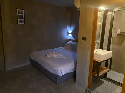 a small bedroom with a bed and a sink at Sukhum Rajamangala-Phatthanakan Rooms in Bangkok
