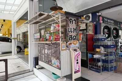 a store with a drink stand in a store at Happyland Guesthouse in Bangkok